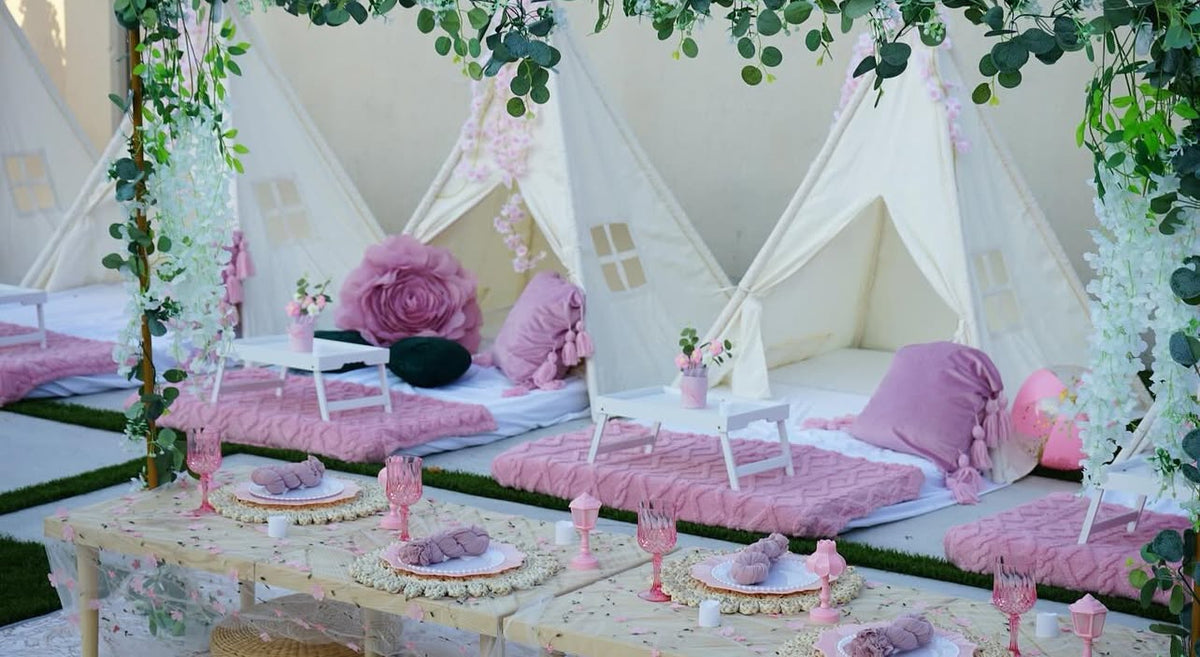 Floral teepees with blush bedding and a styled picnic table