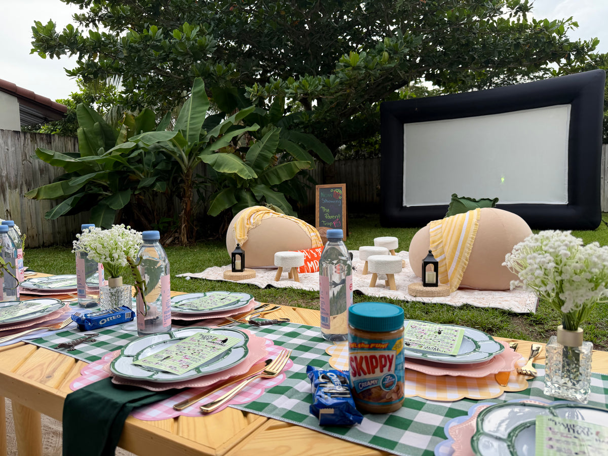 Outdoor movie screen with cozy lounge seating and picnic tables